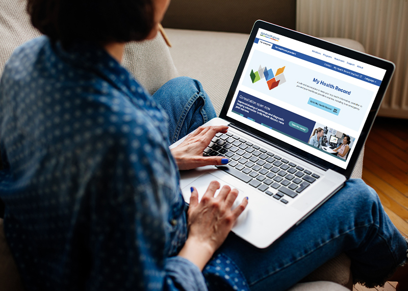 Cropped image of woman using laptop