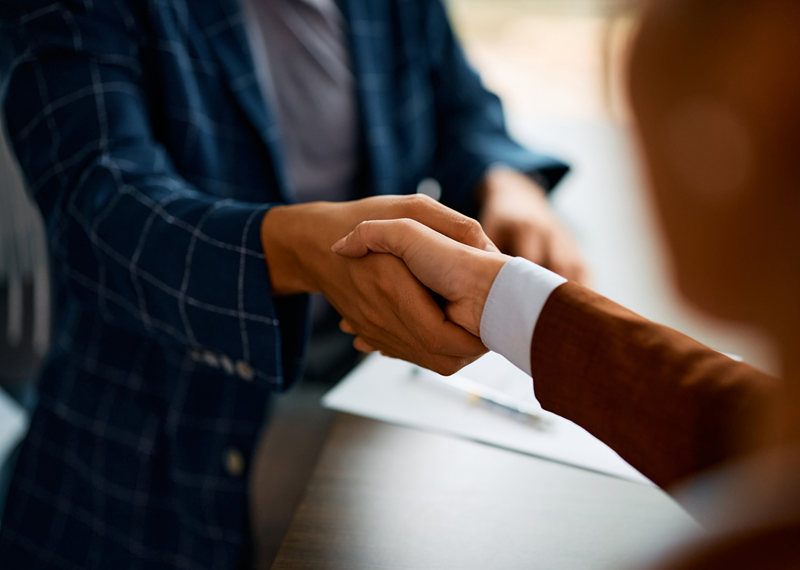 Close up of business people shaking hands in the office.