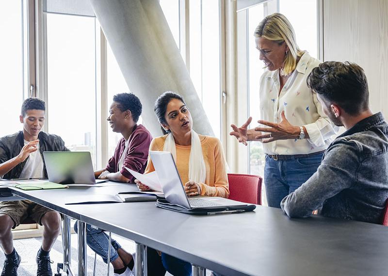 Person teaching adults in a classroom.